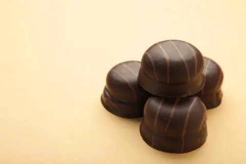 Chocolate sweets on a beige background with copy space. Stock Photos