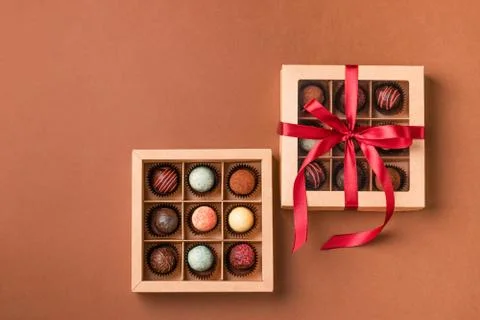 Chocolate sweets from various chocolate in a box a satin ribbon brown background Stock Photos