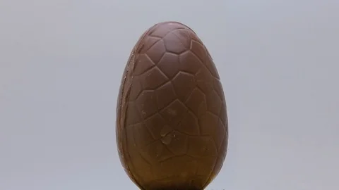 Chocolate syrup dripping on Easter egg on rotating platform Stock Footage 127858534