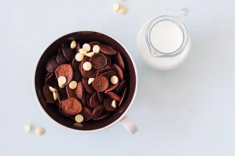 Chocolate tiny pancake cereal with white chocolate in a bowl and milk. Foto stock