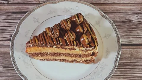 Chocolate triangular spongy cake piece filled and topped with chocolate Stock Footage 284937832