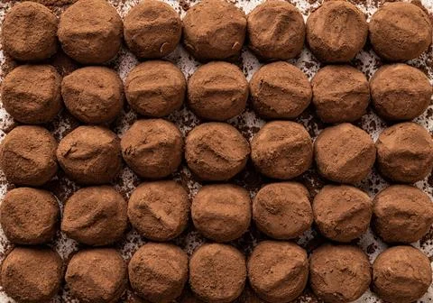 Chocolate truffle candy background. Rows of tasty truffle balls texture. Stock Photos