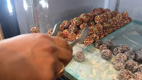 Chocolate truffles being carefully packaged into an elegant gift box Stock Footage 295506121