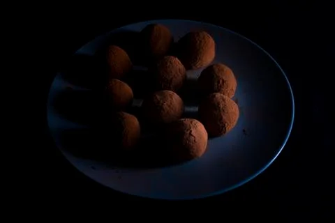 Chocolate truffles with nuts on dark background. Flat lay. Low key photo Stock Photos