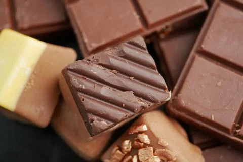 Chocolates arranged in a tempting display on a dark surface Stock Photos