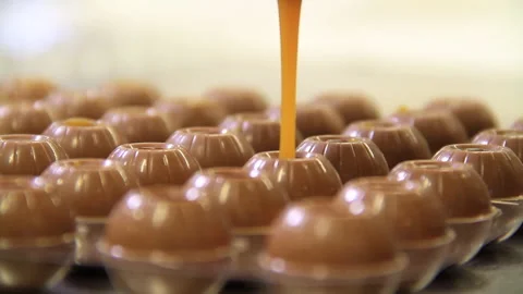Chocolates being filled with caramel macro shot Stock Footage 139106235