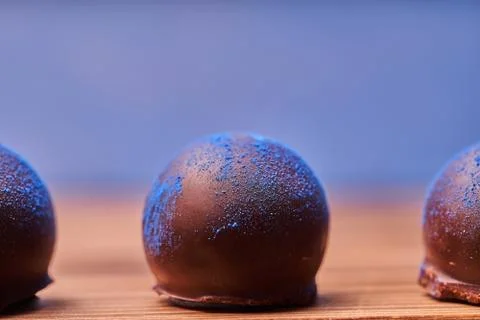 Chocolates with blue algae on blue background. Stock Photos
