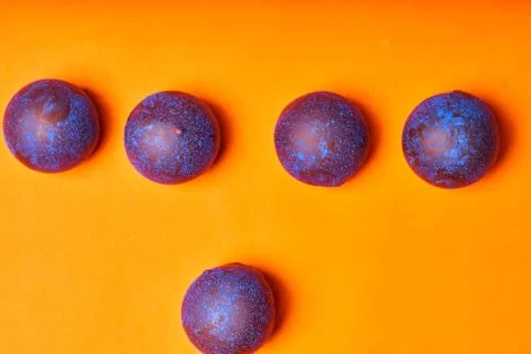 Chocolates with blue algae on colored background. Stock Photos