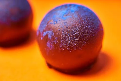 Chocolates with blue algae on colored background. Stock Photos