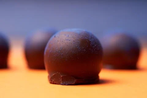 Chocolates with blue algae on colored background. Stock Photos