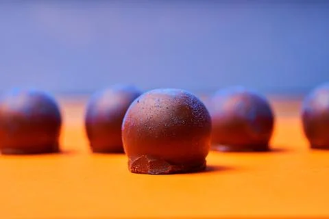Chocolates with blue algae on colored background. Stock Photos