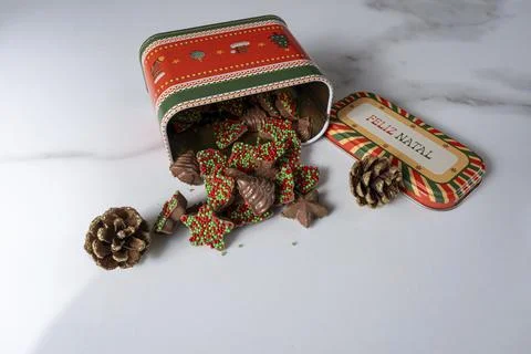 Chocolates in different shapes emerging from a cookie tin. Stock Photos