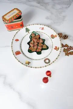 Chocolates in different shapes next to a tin and Christmas decorations vert.. Stock Photos