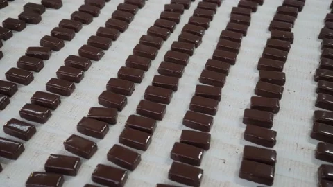 Chocolates moving along a conveyor line in a factory  Video stock 146160940