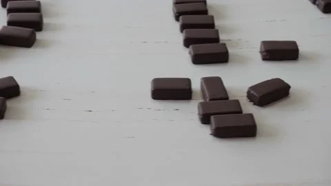 Chocolates moving along a conveyor line in a factory  库存影片 146161195