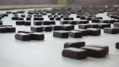 Chocolates moving along a conveyor line in a factory  Stock Footage 146161573