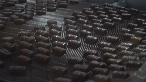 Chocolates moving along a conveyor line in a factory  Video stock 146161752