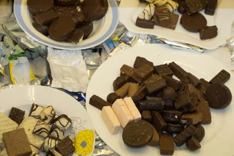 Chocolates on plate on black background . Stock Photos