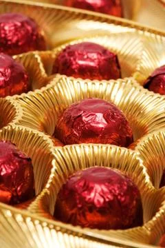 Chocolates in a red foil Stock Photos
