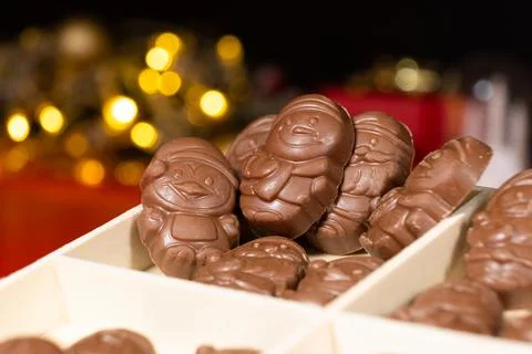 Chocolates in the shape of Christmas figures on the background of a flashing Stock Photos