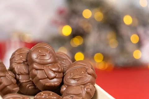 Chocolates in the shape of Christmas figures on the background of a flashing Stock Photos