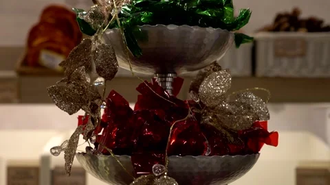 Chocolates wrapped in red and green wrappers on a shelf display. Tilt 4K Stock Footage 326523860
