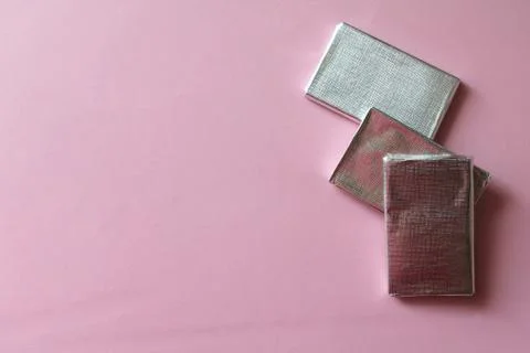 Chocolates wrapped in silver foil isolated on pink surface Stock Photos