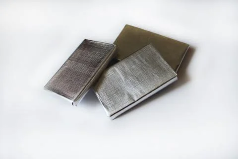 Chocolates wrapped in silver foil isolated on white surface Stock Photos