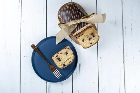 Chocotone slice on a plate, next to a fork and a Chocote with a ribbon bow. Stock Photos