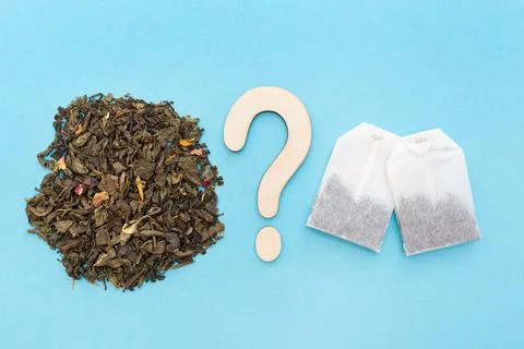 Choice between loose leaf green tea and tea bags. Wooden question mark. Blue  Foto stock