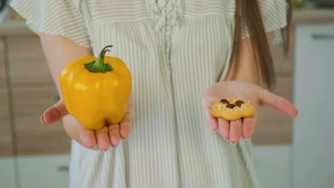 Choice pepper against biscuit. Starting healthy eating or junk food. Female Stock Footage 144757053