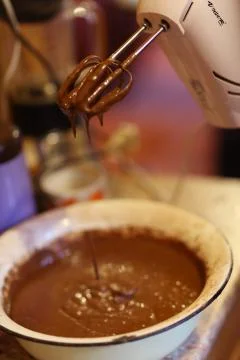 Chokolate dough for cake in cooking process with mixer in bowl Stock Photos