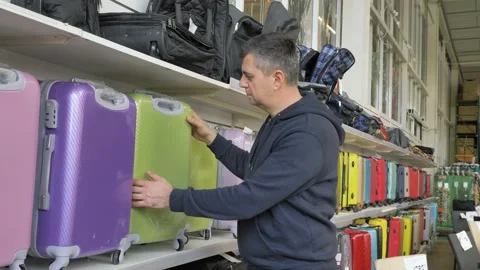 Chooses a suitcase in a supermarket Stock Footage 133236493