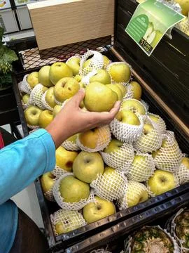 Choosing apples in a mini market Stock Photos