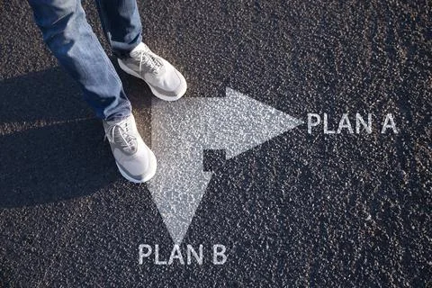 Choosing between Plan A and Plan B. Man near pointers on road, closeup view Stock Photos
