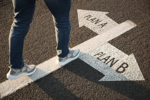 Choosing between Plan A and Plan B. Man near pointers on road, closeup view Stock Photos