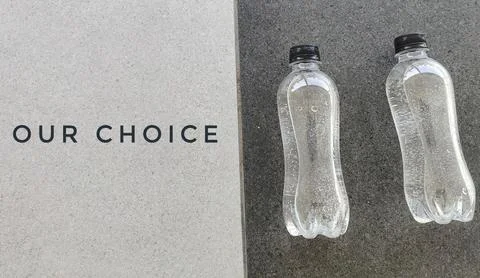 Choosing Between Plastic Water Bottles on Minimal Concrete Surface Foto stock