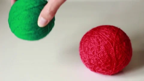 Choosing between red and green yarn balls Stock Footage 76039306