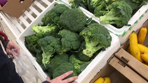 Choosing broccoli at the grocery store 库存影片 83049144