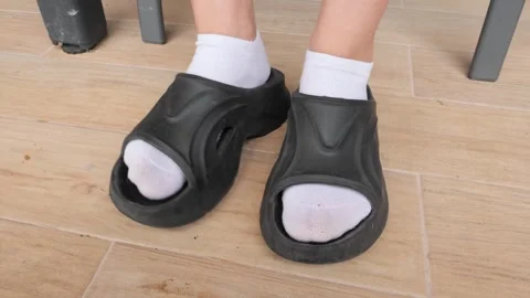Choosing comfortable slide sandals for relaxing at home on a sunny day Vidéo 288520260