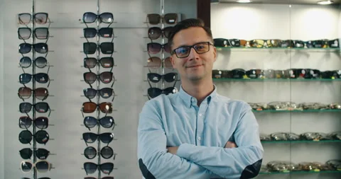Choosing glasses. Client in optics. Selective focus. Man looking at camera Stock Footage 159506347