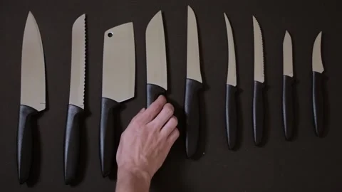 Choosing a kitchen knife on black background seamless looping hand picking knife Stock Footage 141468740