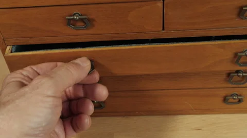 Choosing an old skeleton key from a mysterious chest of drawers Stock Footage 197477180