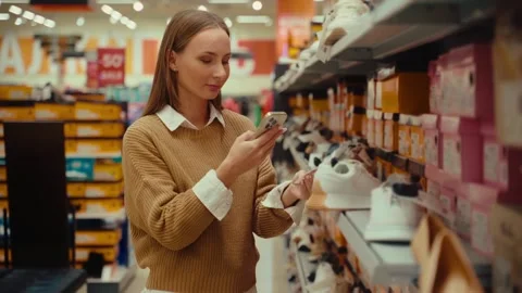 Choosing the perfect pair of shoes while shopping in a retail store Stock Footage 293675421