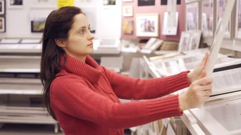 Choosing picture frames in store Stock Footage 72216758
