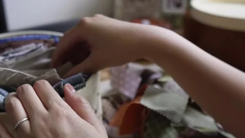 Choosing from a pile of small fabric scraps Stock Footage 315084831