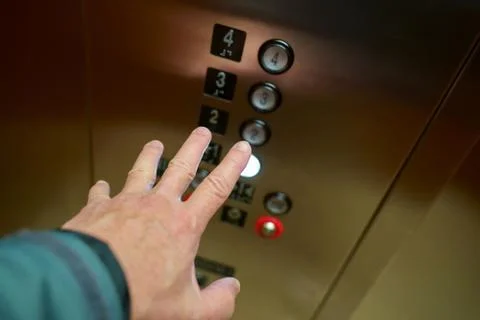 Choosing the right floor on the elevators control panel. Stock Photos