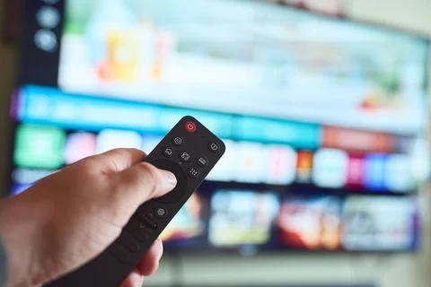 Choosing a show with a remote control Stock Photos