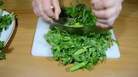 Chop the celery with a two-handled crescent knife. Stock Footage 153329488