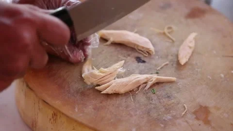Chop the chicken meat until it is placed in a container containing chicken Stock Footage 270347157
